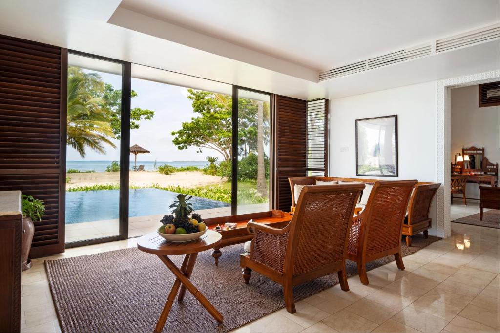 The Residence Zanzibar luksusa numurs ar skatu uz baseinu un okeānu.