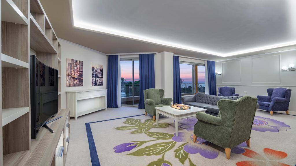 Pine Beach Belek viesnīcas numurs ar modernu dizainu un saulrieta skatu.
