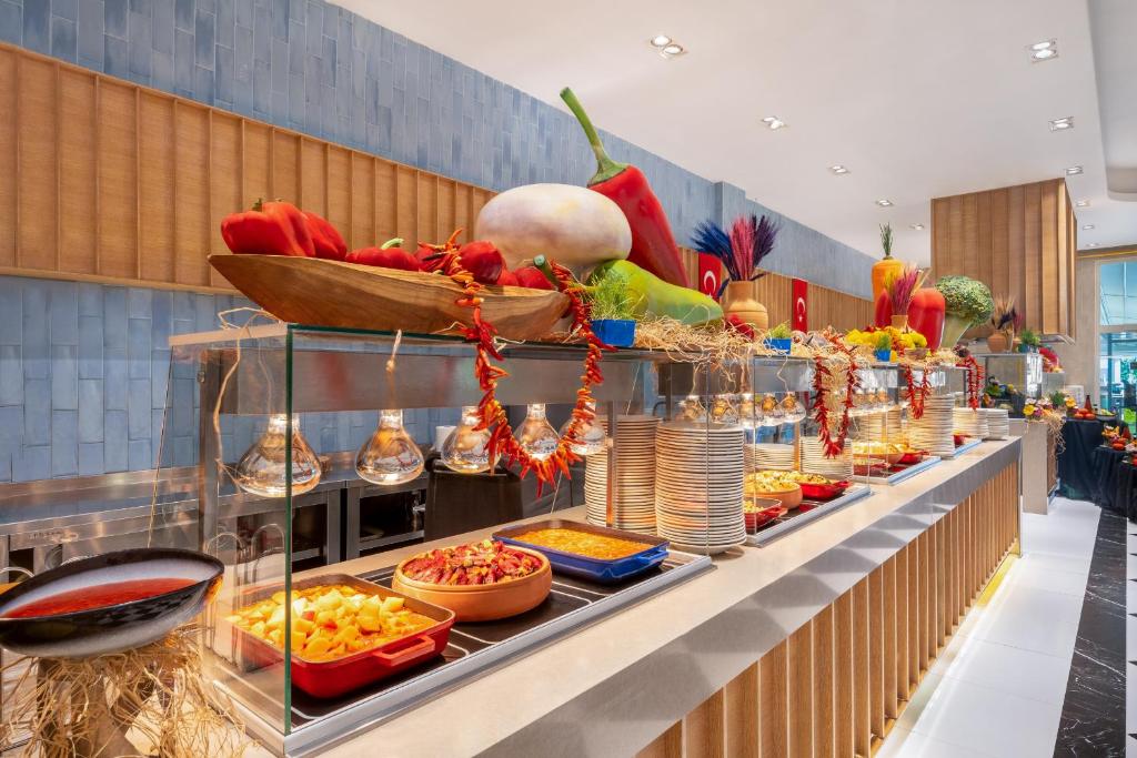 Delphin Imperial Hotel bufete ar krāsainiem ēdieniem un augļu dekorācijām.
