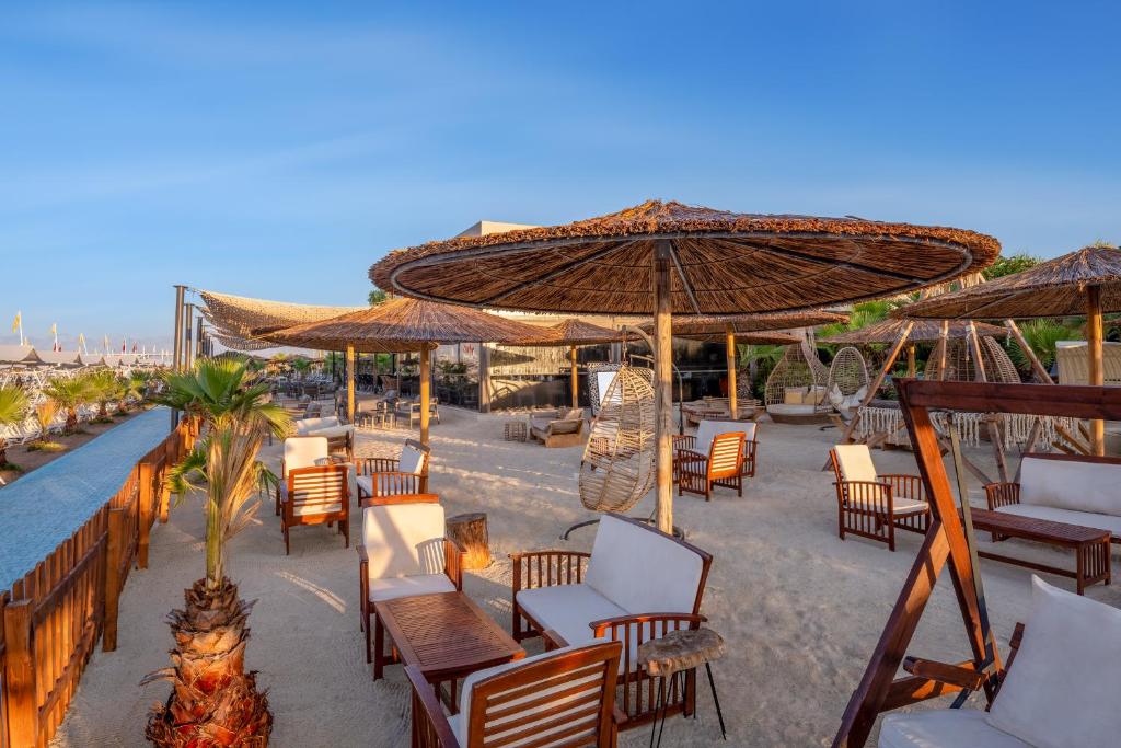 Delphin Imperial Hotel pludmales zona ar šikiem atpūtas krēsliem un lietus aizsargiem