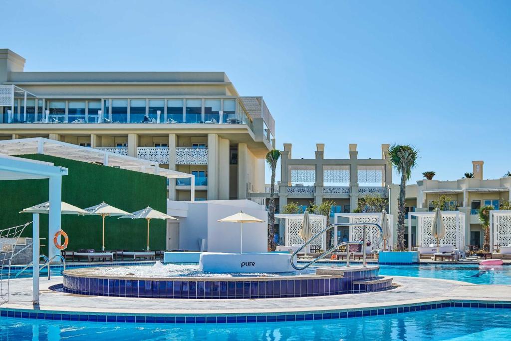 Steigenberger Pure Lifestyle baseins ar saulessargiem saulainā dienā.