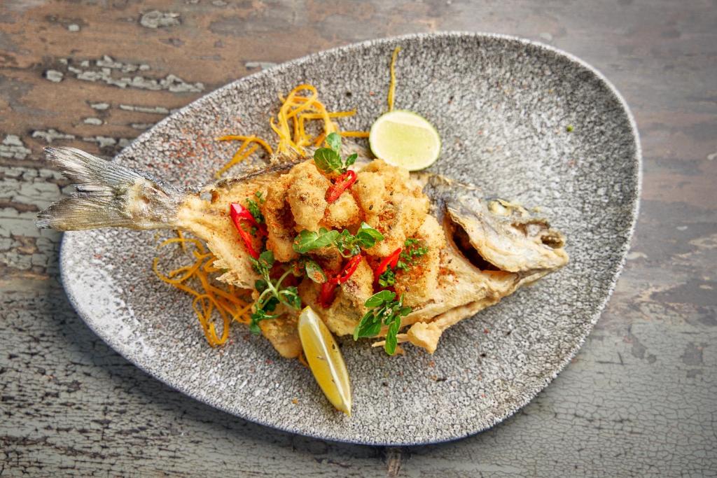 Garda cepta zivs šķīvī ar citrona šķēli