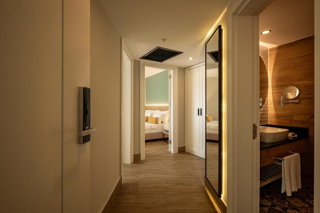 Moderns koridors numura viesnīcā Sailor’s Beach Club ar skatu uz vannas istabu.
