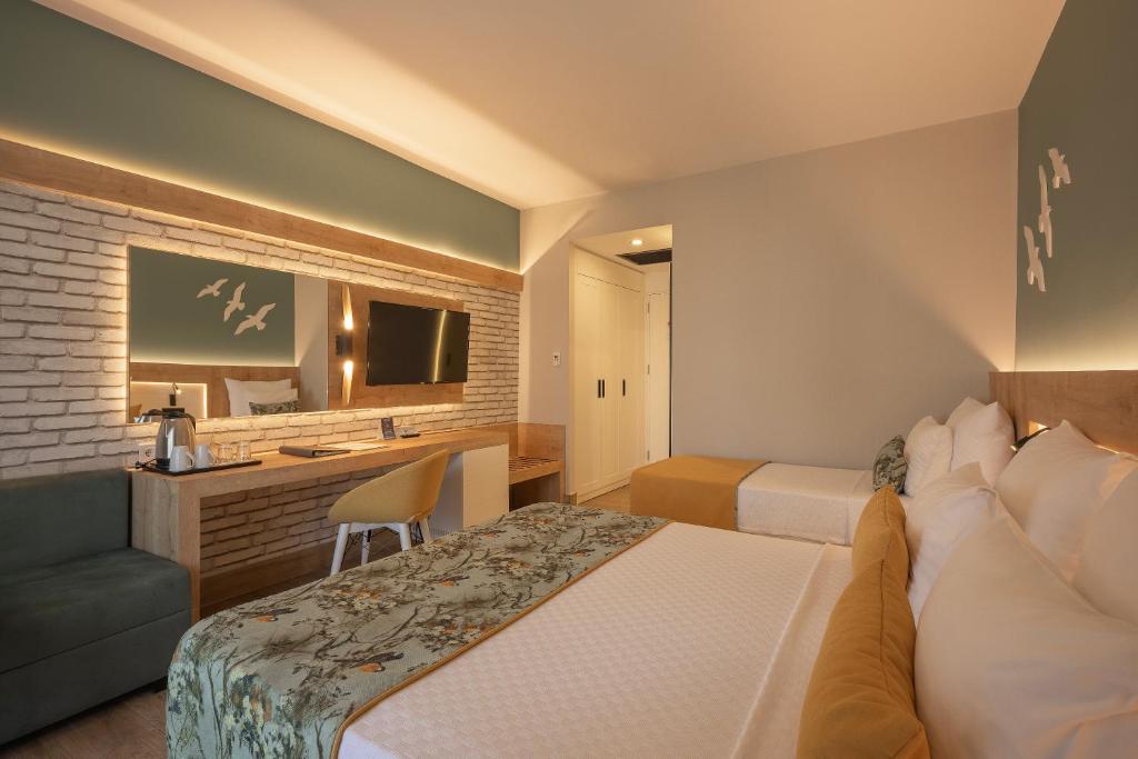 Mūsdienīgs numurs viesnīcā Sailor’s Beach Club ar ērtām gultām un televizoru.