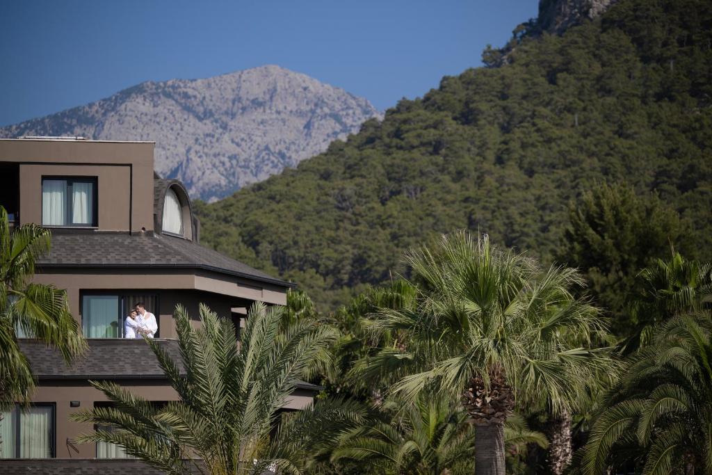 Pāris, kas bauda skatu no Sailor’s Beach Club numura, fona kalni.