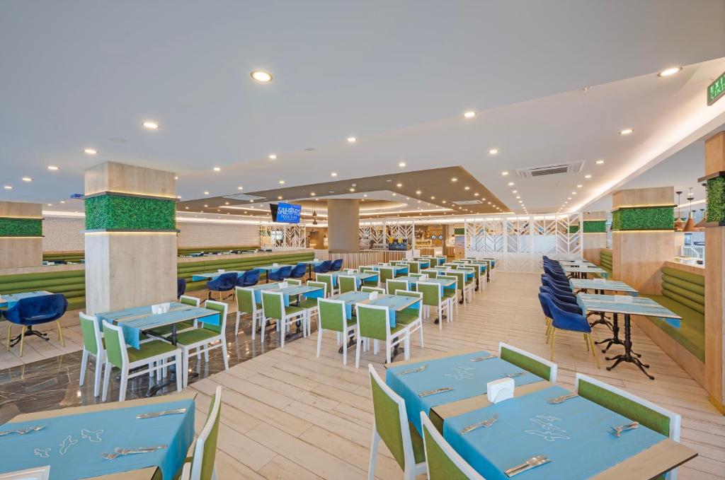 Sailor’s Beach Club restorāns ar zaļiem un ziliem galdiem, gaišs un mūsdienīgs