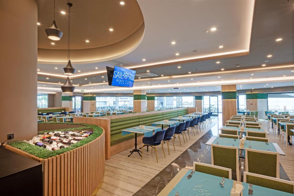 Mūsdienīgs restorāns Sailor’s Beach Club ar zaļām detaļām un ērtām vietām