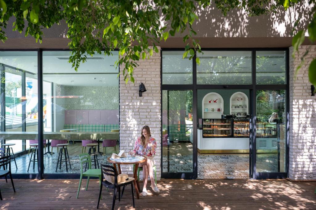 Sailor’s Beach Club, viesmīlīga terase ar kafijas galdiņu un cilvēku, kas lasa.