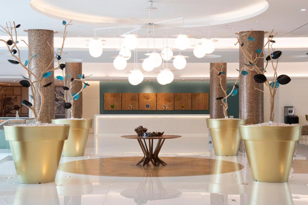 EPIC SANA Algarve Hotel modernais vestibils ar zelta dekoriem un dizaina lampām