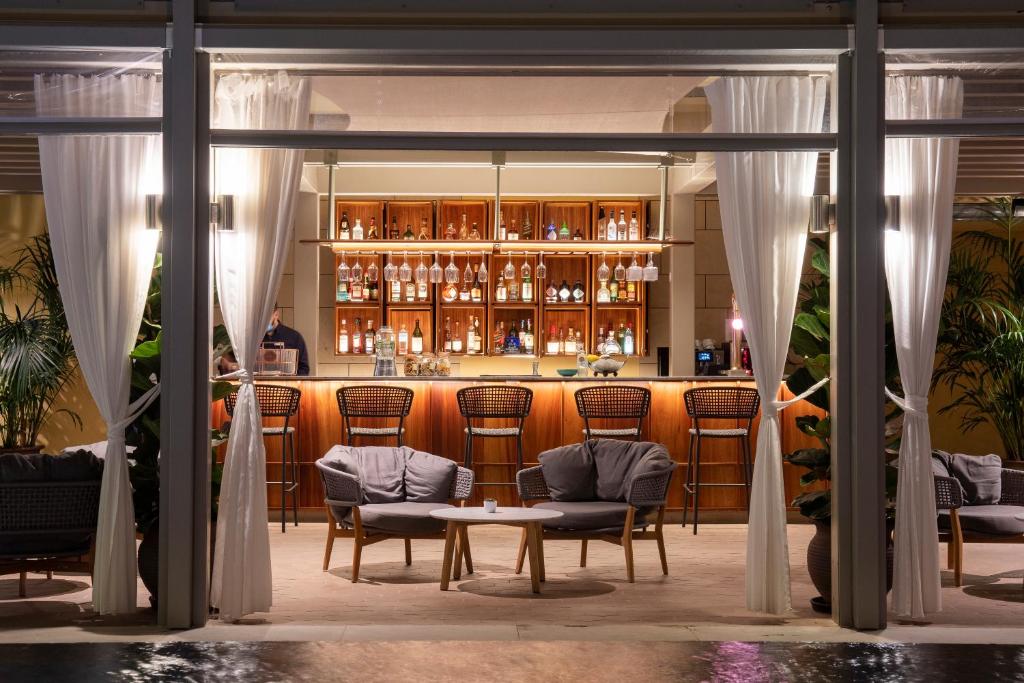 EPIC SANA Algarve Hotel bārs ar āra terasi, ērtiem atzveltnes krēsliem un siltu apgaismojumu.