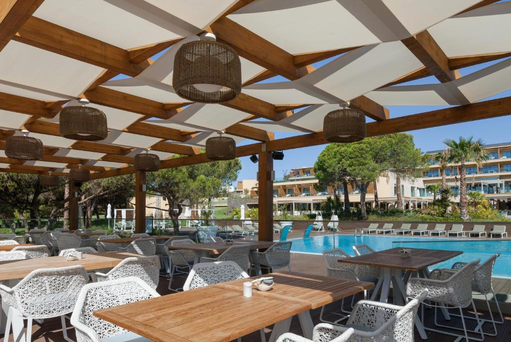 EPIC SANA Algarve Hotel āra restorāna terase ar koka nojumi un skatu uz peldbaseinu