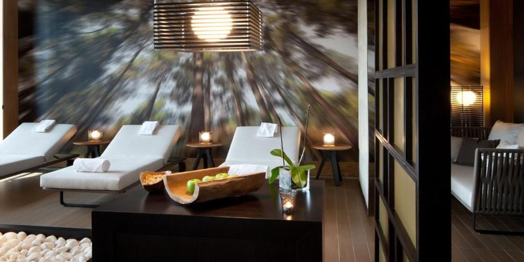 EPIC SANA Algarve Hotel spa relaksācijas zona ar ērtiem zviļņiem un meža motīvu sienu.