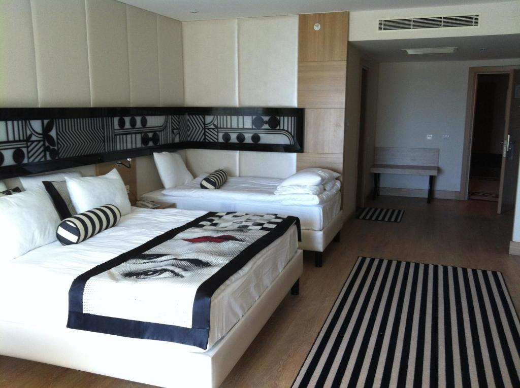 Mūsdienīgs numurs Delphin Imperial Hotel ar divām gultām un stilīgu interjeru.