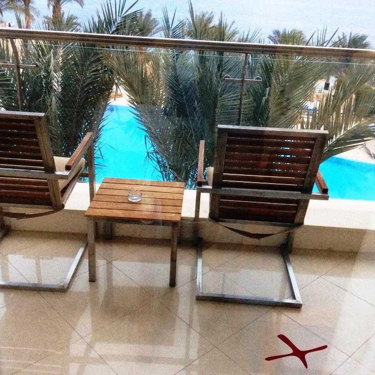 Terase ar koka krēsliem un skatu uz baseinu Xperience Sea Breeze Resort