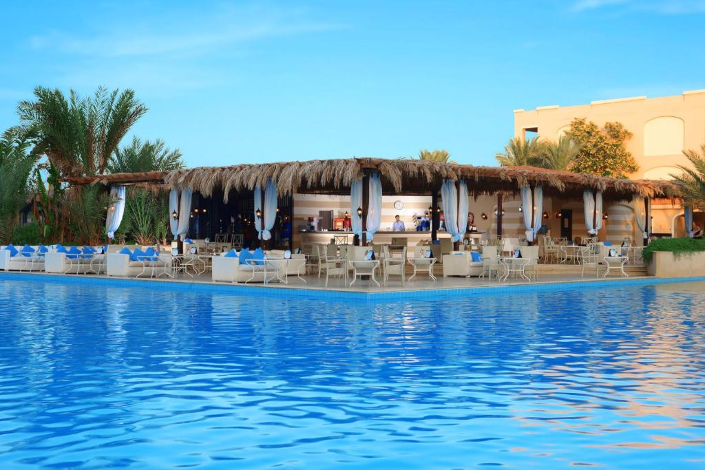 Tropu bārs pie Jaz Aquamarine Resort pie baseina ar ziliem krēsliem