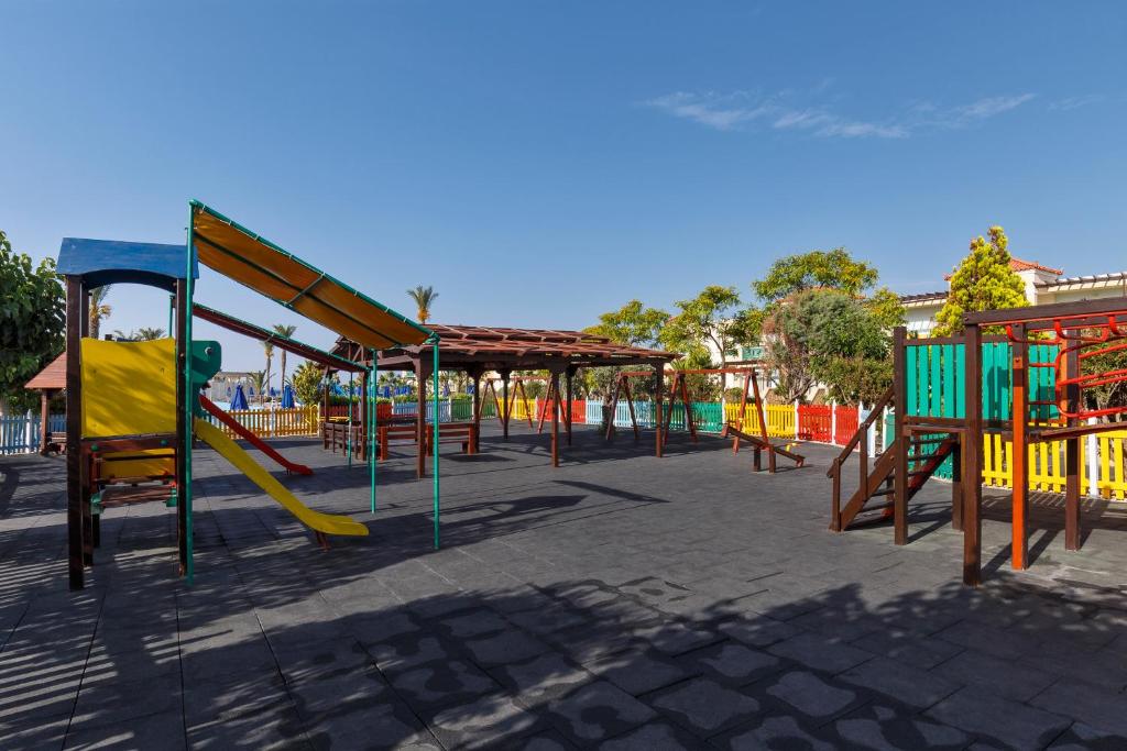 Bērnu rotaļu laukums pie Lindos Princess Beach Hotel ar slidkalniņu un šūpolēm.