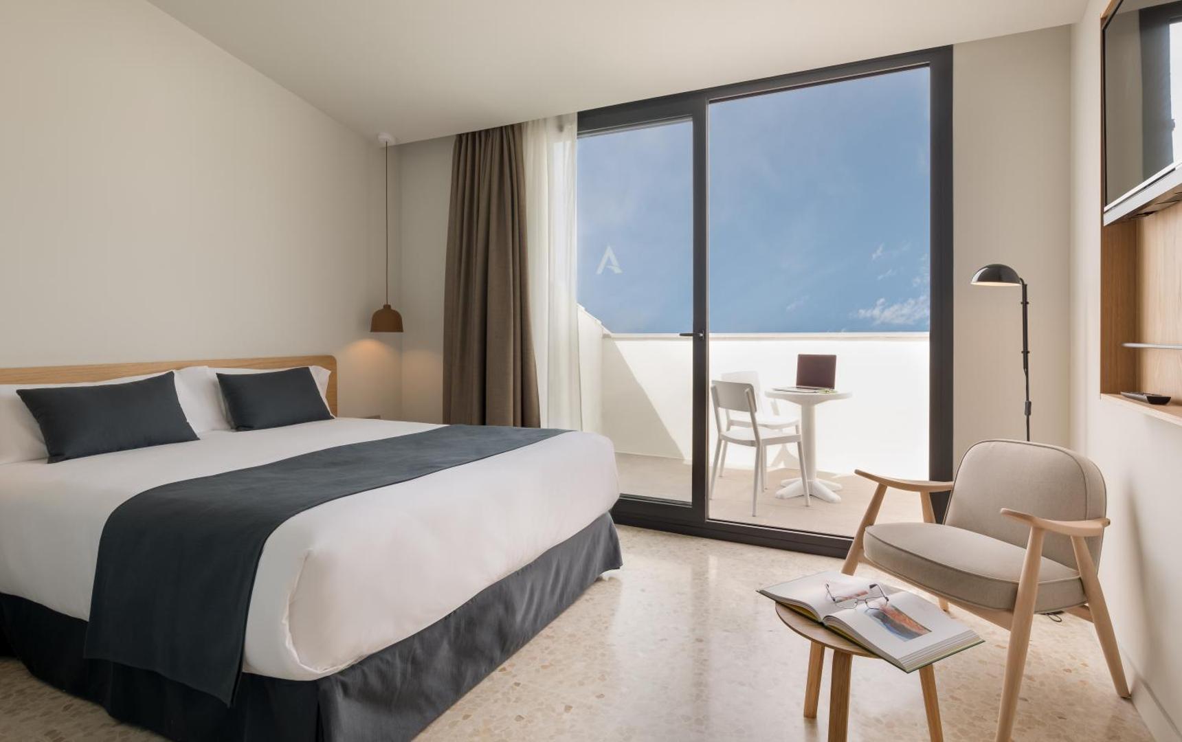 AQUA Hotel Silhouette & Spa numurs ar balkonu, kur atrodas galds un krēsli, piedāvājot vietu atpūtai svaigā gaisā Spānijas piekrastē.