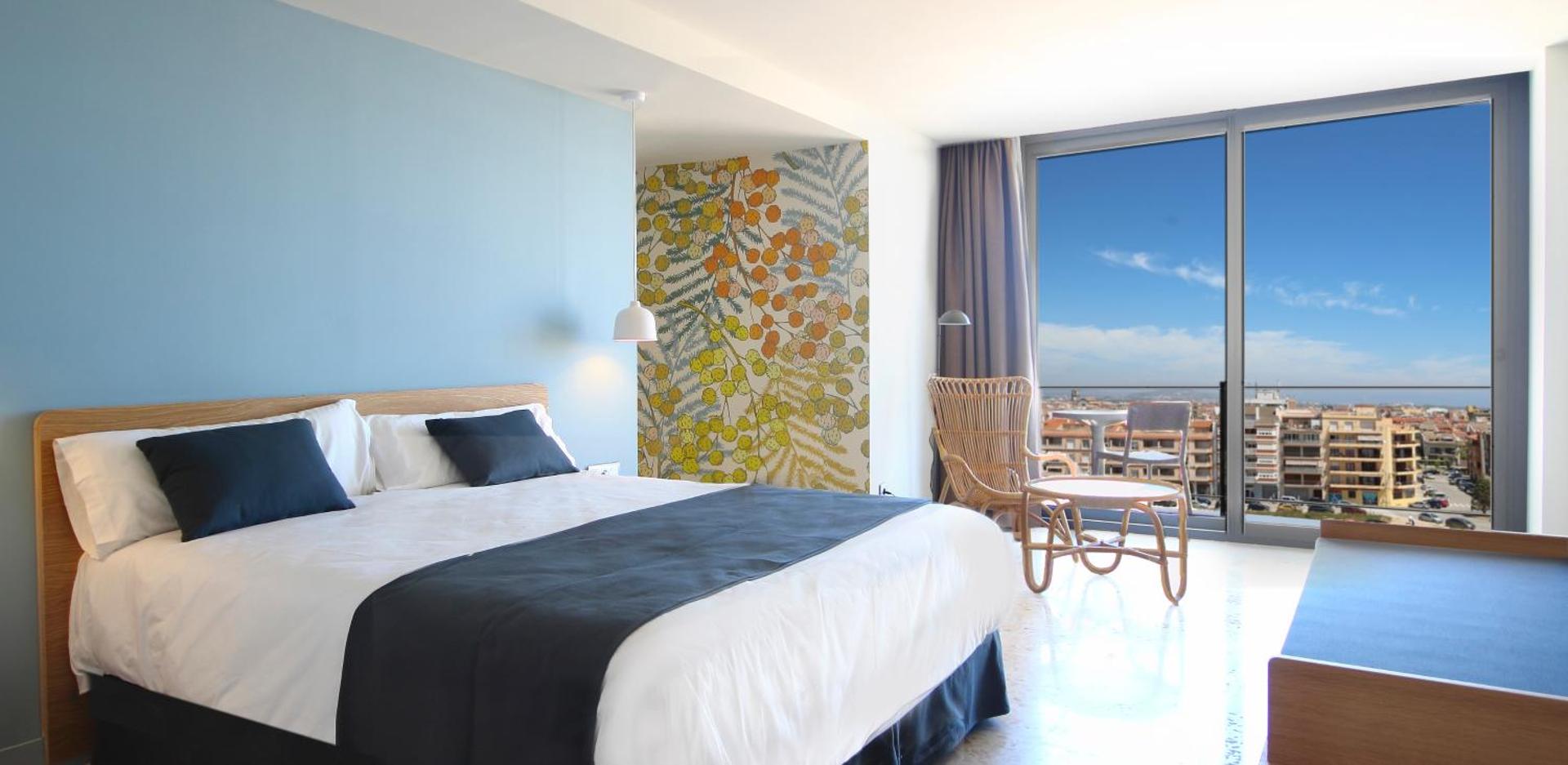 AQUA Hotel Silhouette & Spa plašs numurs ar panorāmas logiem, dizaina mēbelēm un skatu uz Malgrat de Mar pilsētu