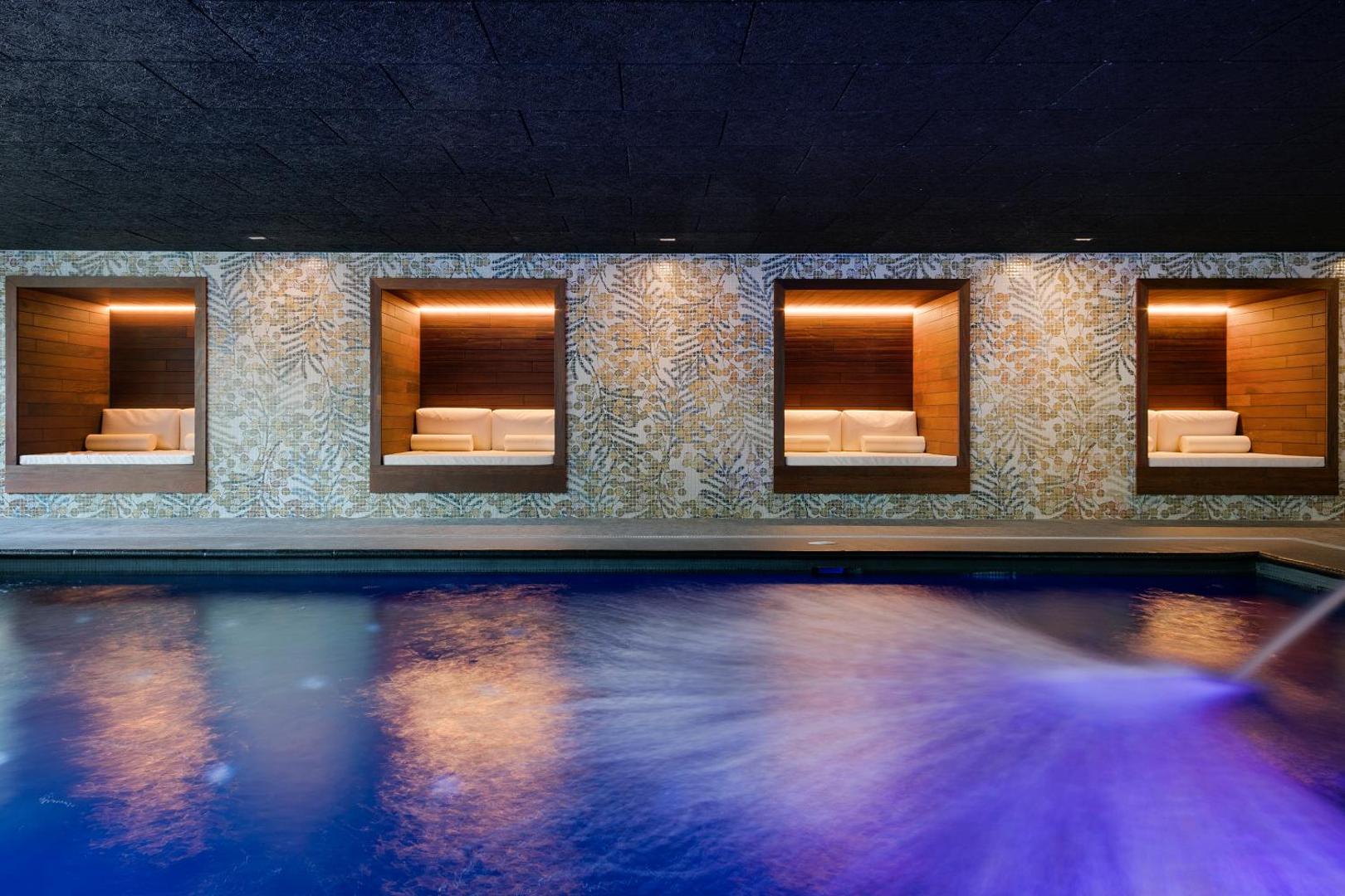 AQUA Hotel Silhouette & Spa iekštelpu baseins ar masāžas strūklu un sienas nišās iebūvētām atpūtas gultām spa centrā