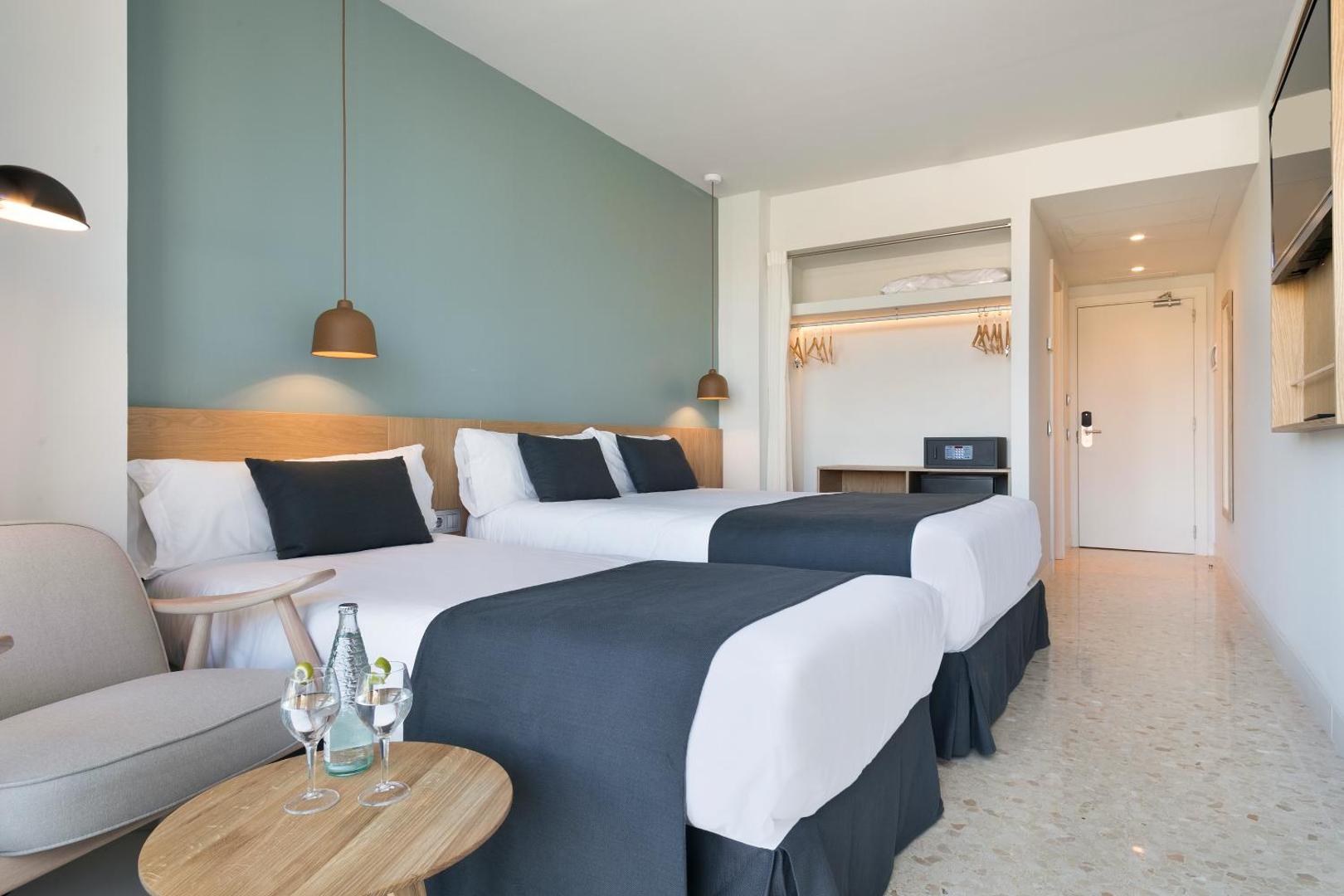 AQUA Hotel Silhouette & Spa divvietīgs numurs ar atsevišķām gultām, modernu apgaismojumu un atvērtā tipa drēbju skapi ar seifu.