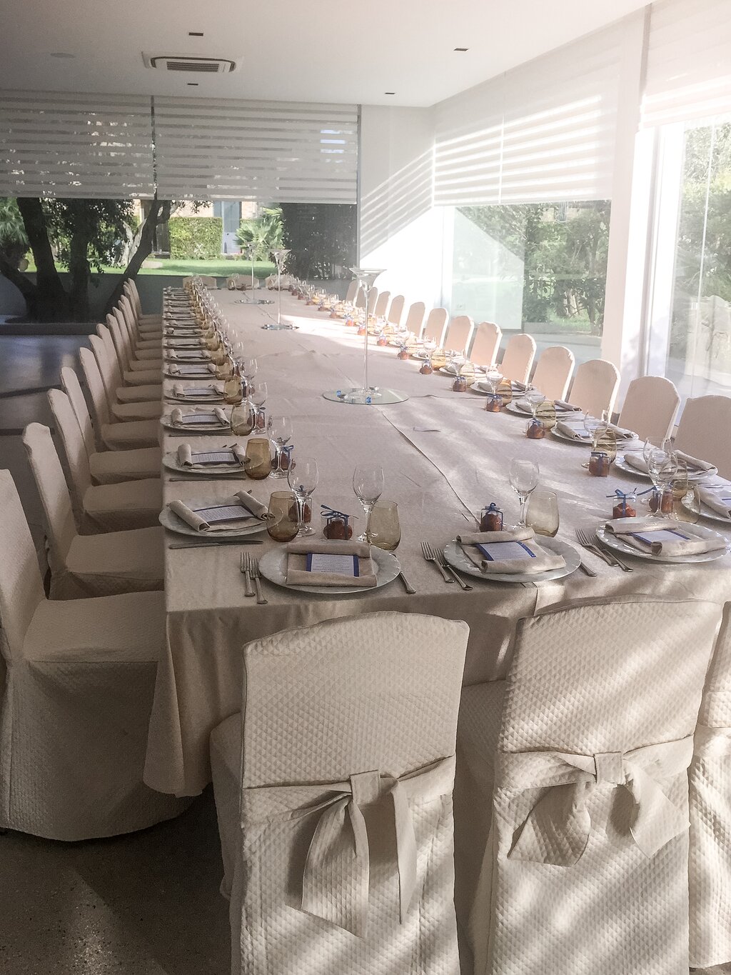 Rada Siri Hotel banketu zāle ar elegantām galda klāšanas dekorācijām.