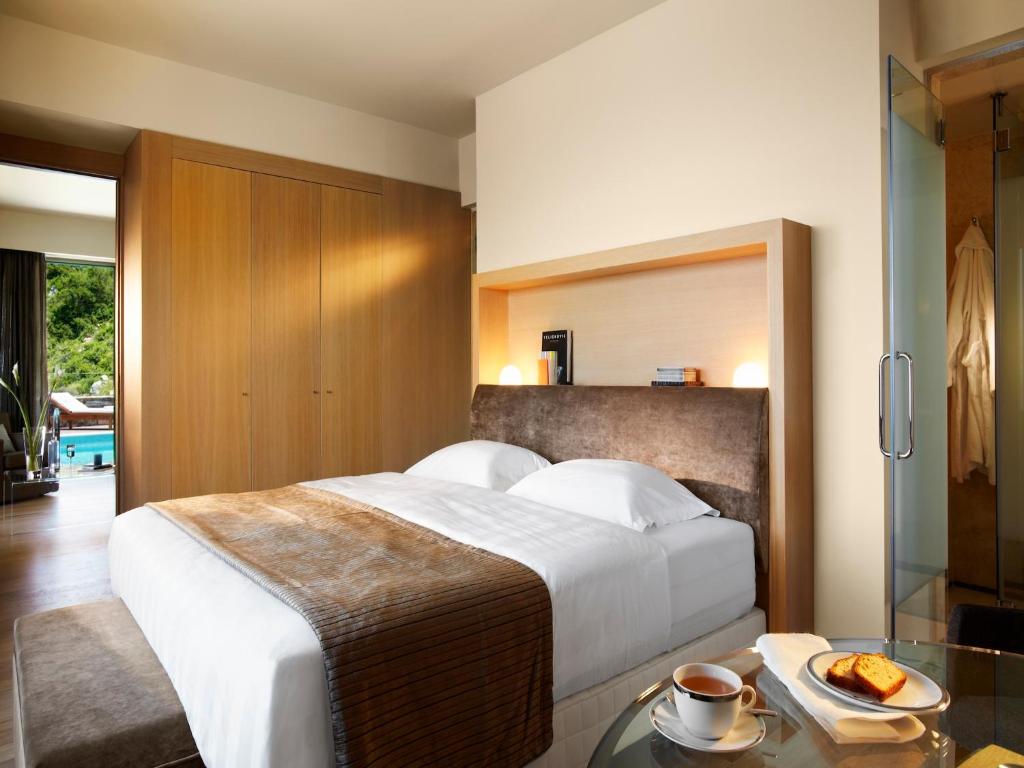 Mūsdienīgs numurs ar gultu un skatu uz piekrasti, Daios Cove Luxury Resort.