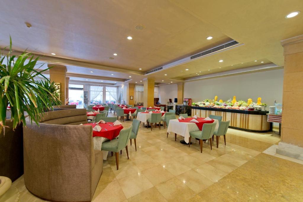 Viesnīcas Amphoras Blu restorāns ar elegantām galdiem un bufeti