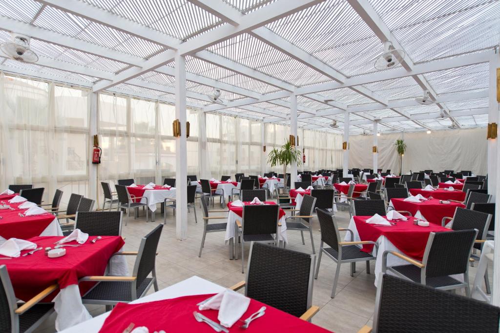 Amphoras Blu restorāns ar sarkaniem galdiem un ērtām krēsliem