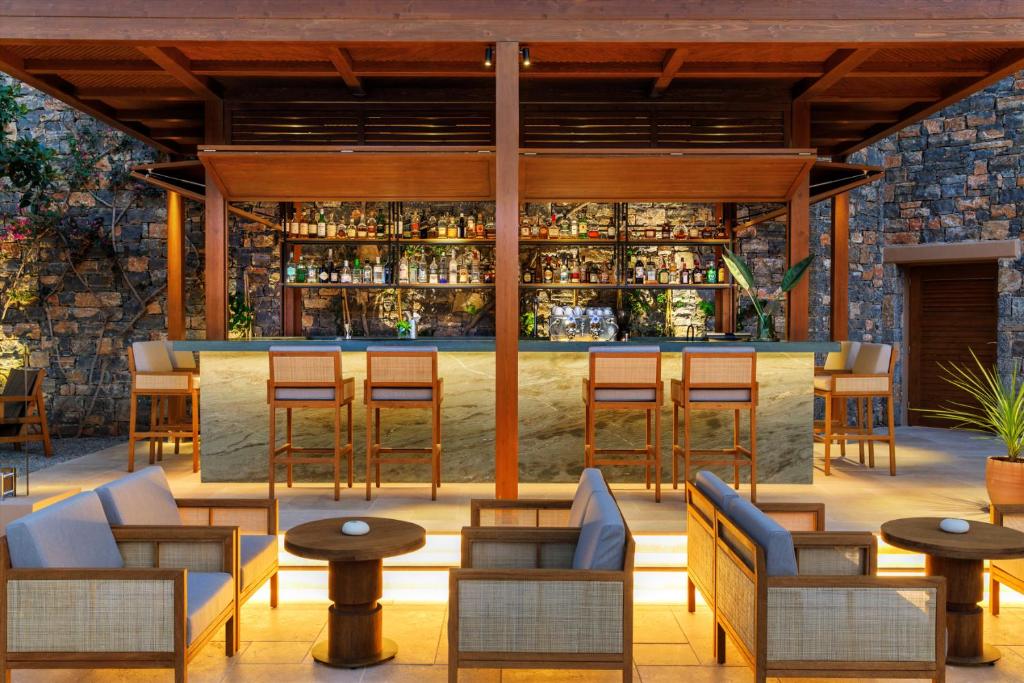 Bārs pie Daios Cove Luxury Resort ar elegantu interjeru un plašu dzērienu izvēli.