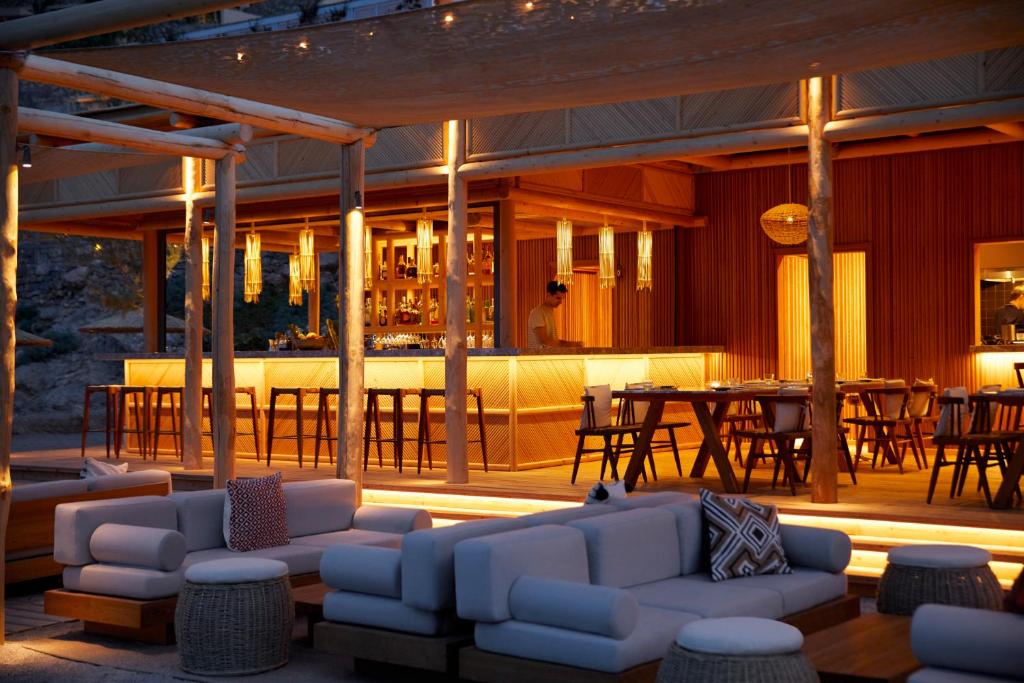 Daios Cove Luxury Resort bārs ar mīkstām mēbelēm un siltu apgaismojumu piekrastē