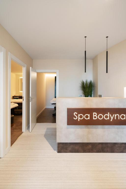 Mūsdienīgs spa reģistratūras interjers ar "Spa Bodyna" zīmi. Telpa ir gaiša un eleganta, piedāvājot relaksējošu atmosfēru.