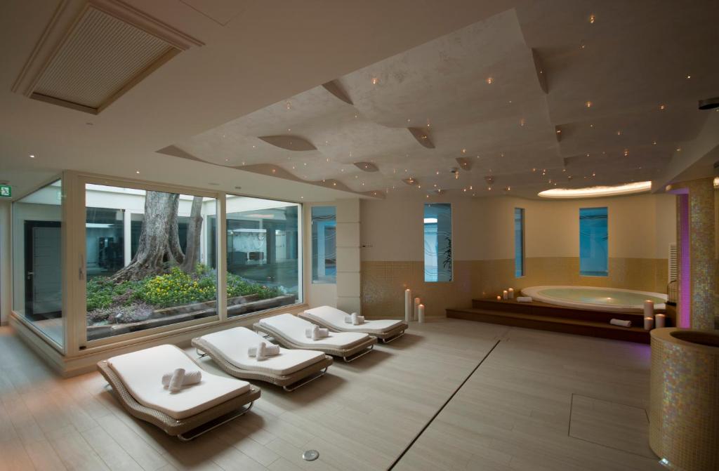 Luksusa spa telpa ar relaksējošām guļvietām un dabas elementiem, kas rada mierīgu atmosfēru. Apgaismojums un interjers veicina relaksāciju un labsajūtu.