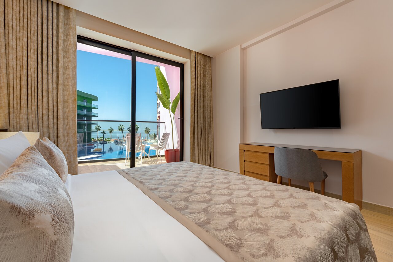 Voco Monaco Dubai numurs ar skatu uz baseinu un jūru.