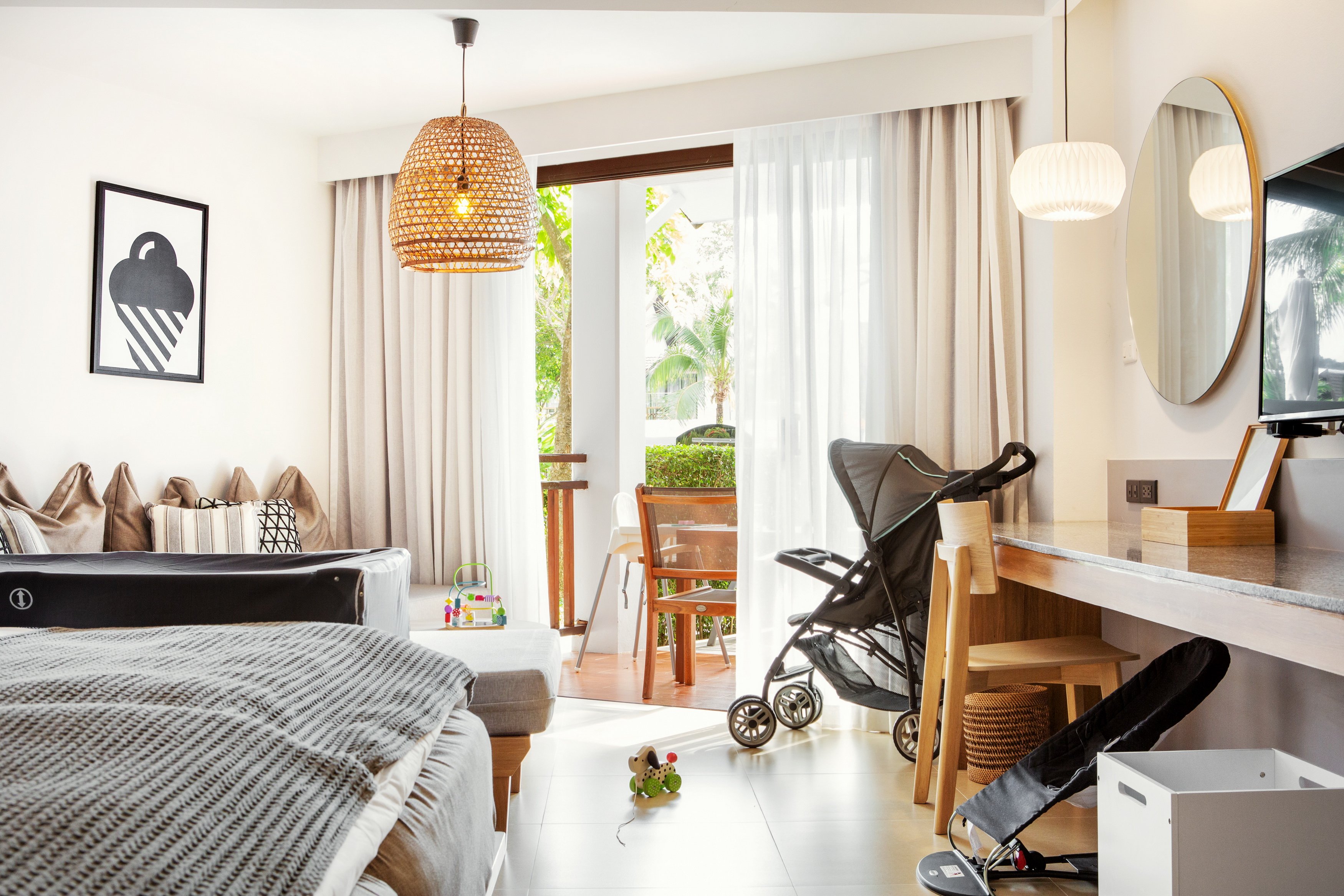 Sunwing Resort Kamala Beach ģimenes numurs ar bērnu gultiņu, ratiņiem un rotaļlietām, skats uz balkonu un dārzu Taizemē.
