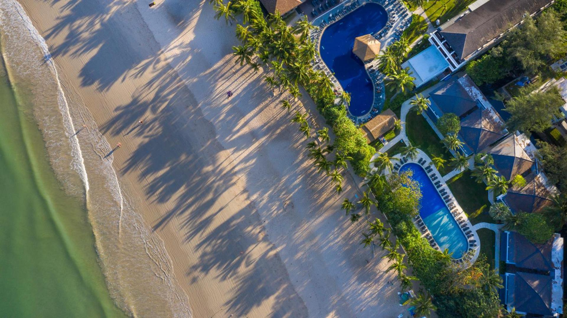 Sunwing Resort Kamala Beach skats no putna lidojuma uz baseiniem, palmu dārzu un blakus esošo smilšu pludmali Puketas piekrastē.