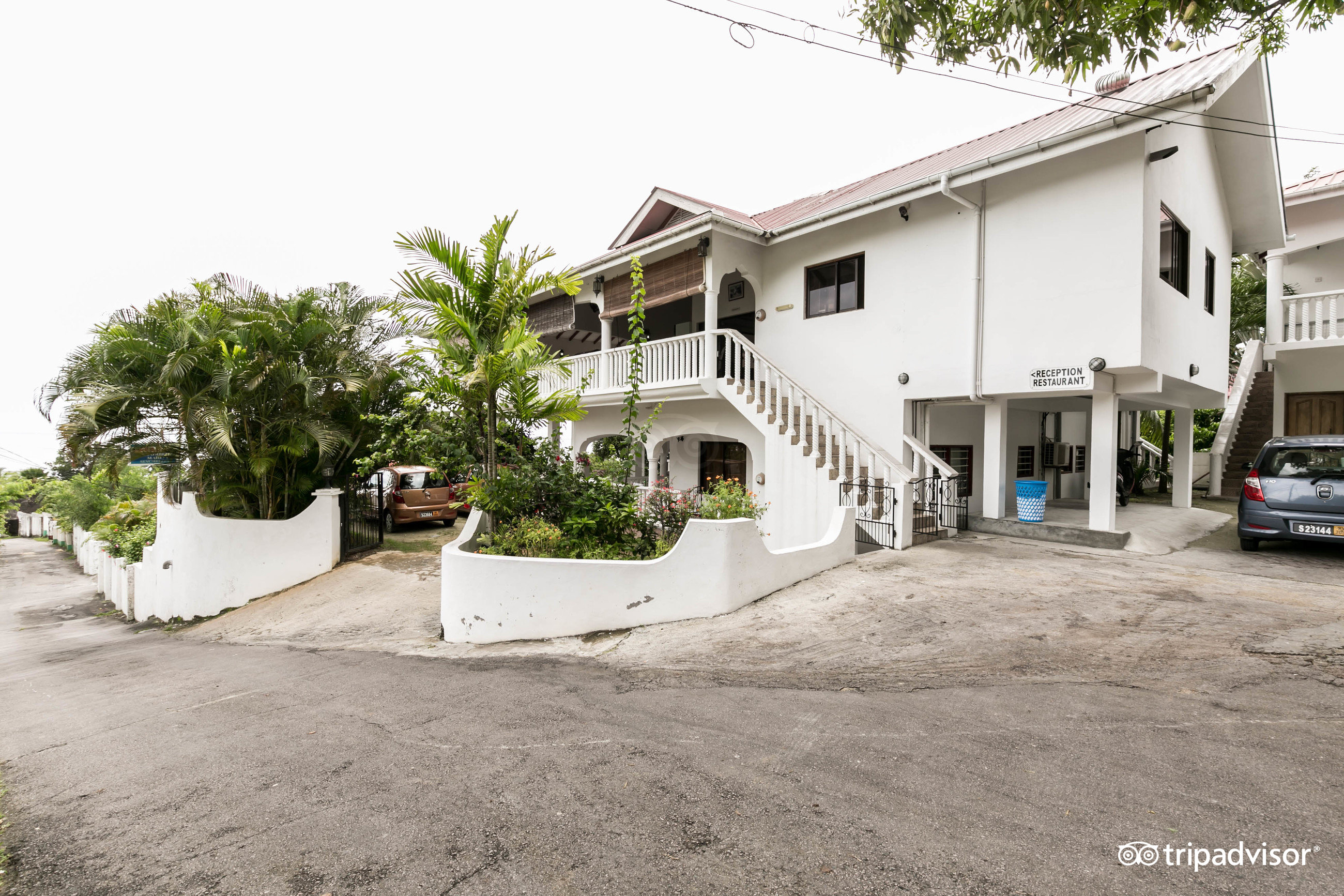 Casadani viesnīcas fasāde ar dārzu un autostāvvietu.