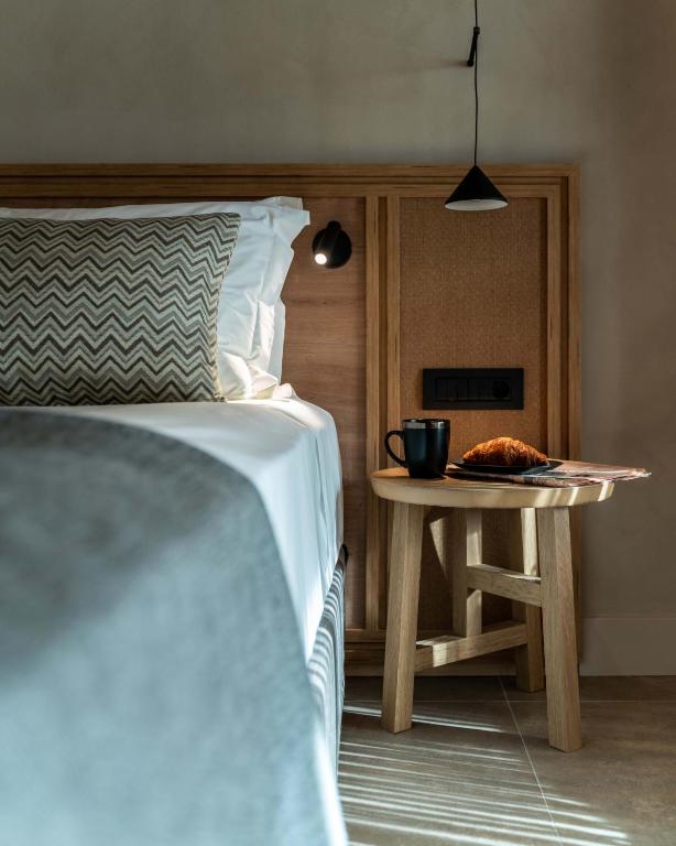 Mūsdienīgs numurs Helea Lifestyle Beach Resort ar ērtu gultu un koka galdiņu.