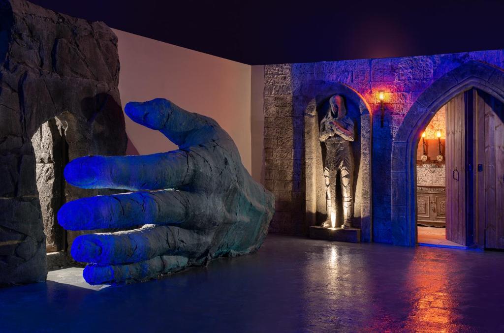 Milzīga roka un statuja interjerā Helea Lifestyle Beach Resort