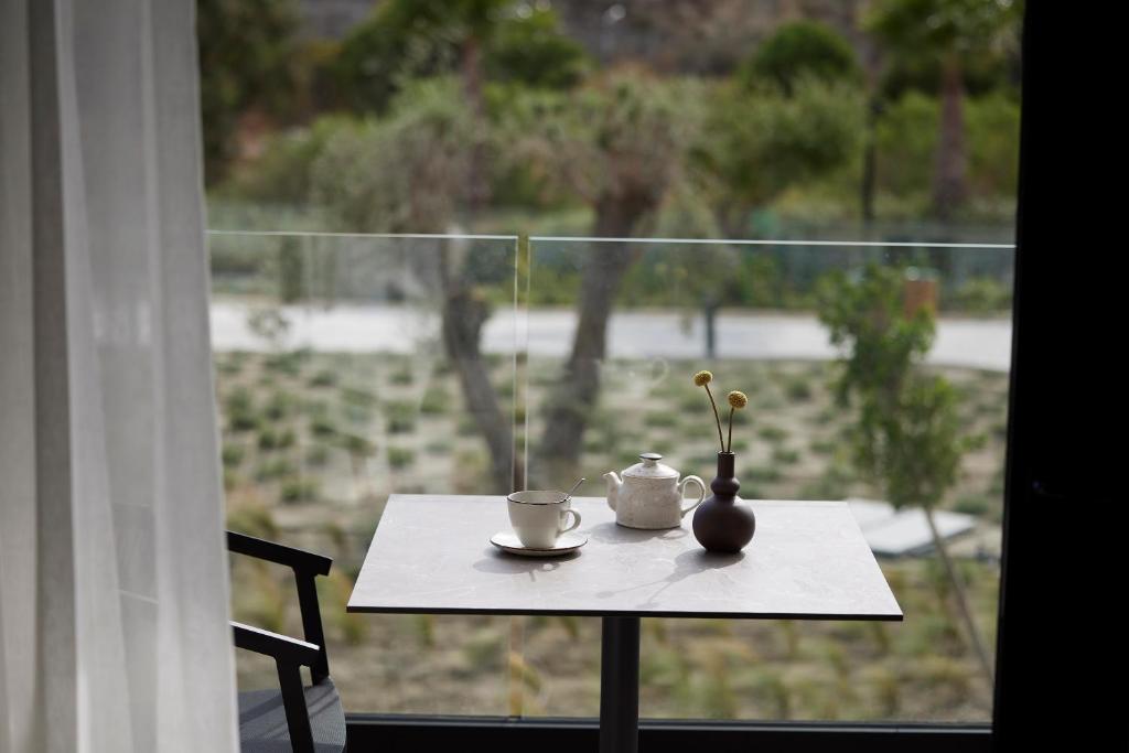 Tēja un kafija uz galda Helea Lifestyle Beach Resort balkonā.