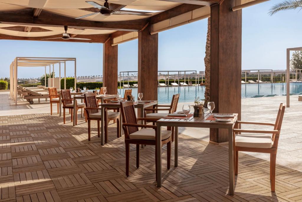 Steigenberger Makadi āra restorāns pie baseina ar ēdamgaldiem un krēsliem