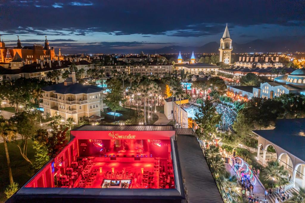 Skats uz Swandor Hotels & Resorts Topkapi Palace nakts atmosfēru ar apgaismotiem baseiniem un restorāniem.