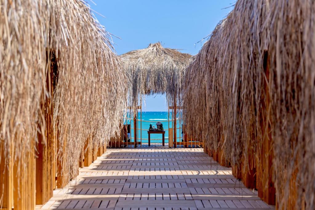 Swandor Hotels & Resorts Topkapi Palace, koka celiņš pie jūras ar salmu jumtiem