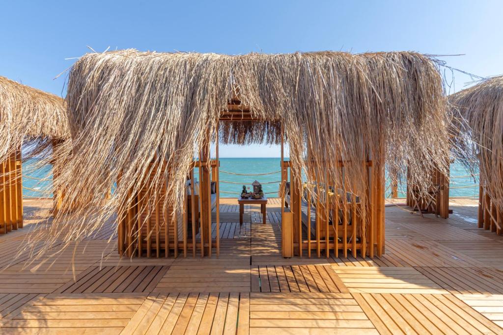 Atpūtas zona piekrastē Swandor Hotels & Resorts Topkapi Palace ar salmu jumtiem.