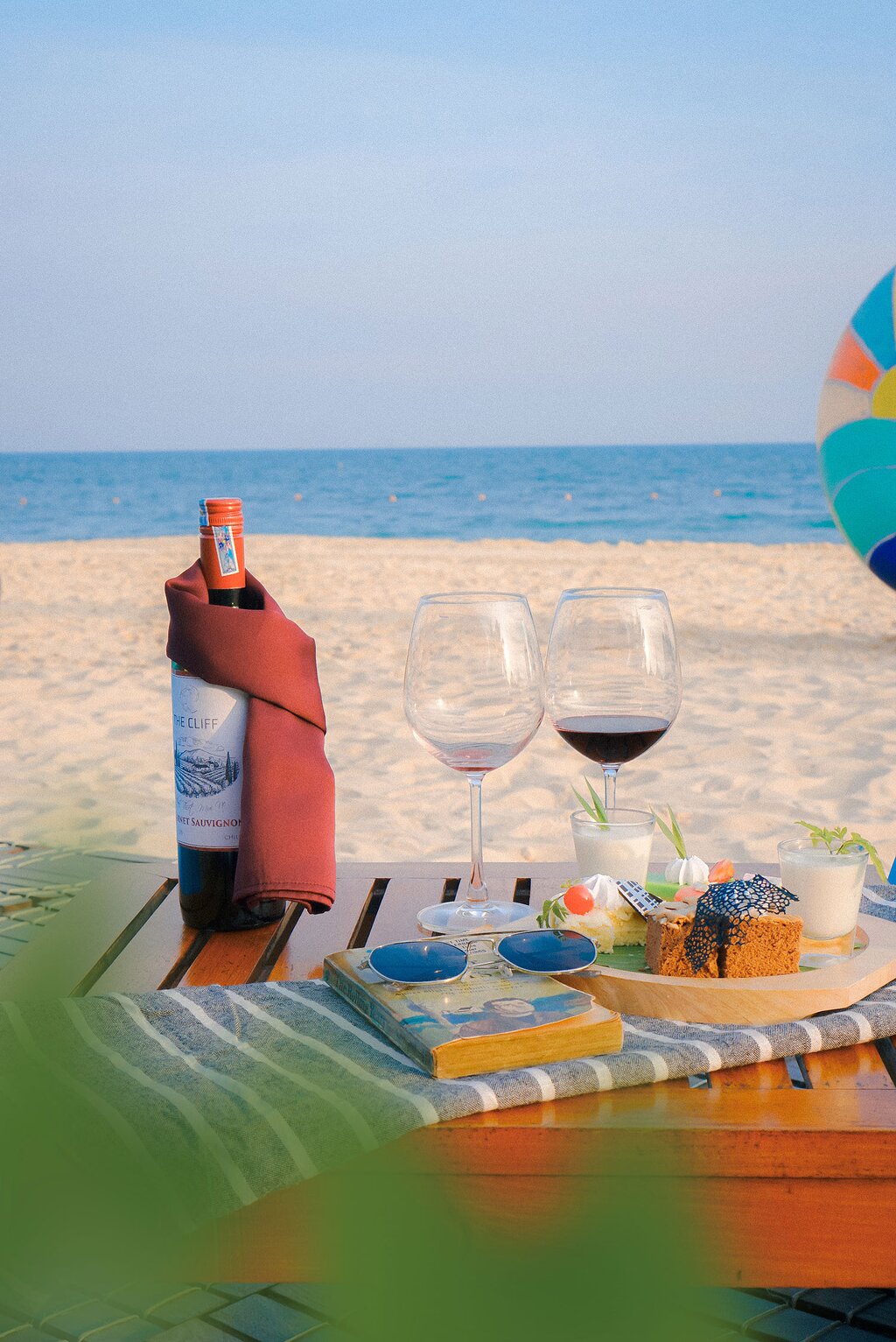 The Cliff Resort & Residences pludmales pikniks ar vīnu un uzkodām.
