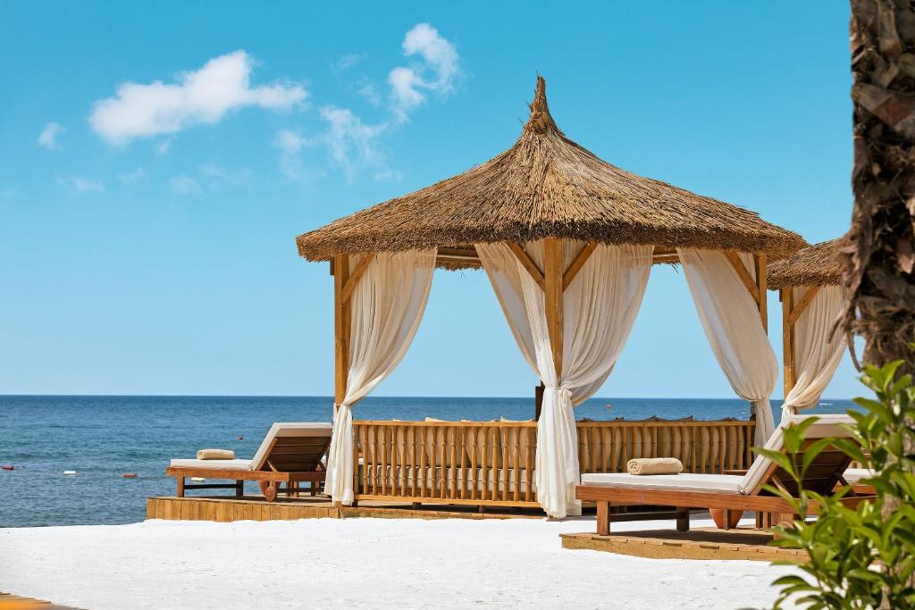 Bamboo pavilions piekrastē pie Titanic Mardan Palace ar plūstošām aizkars.