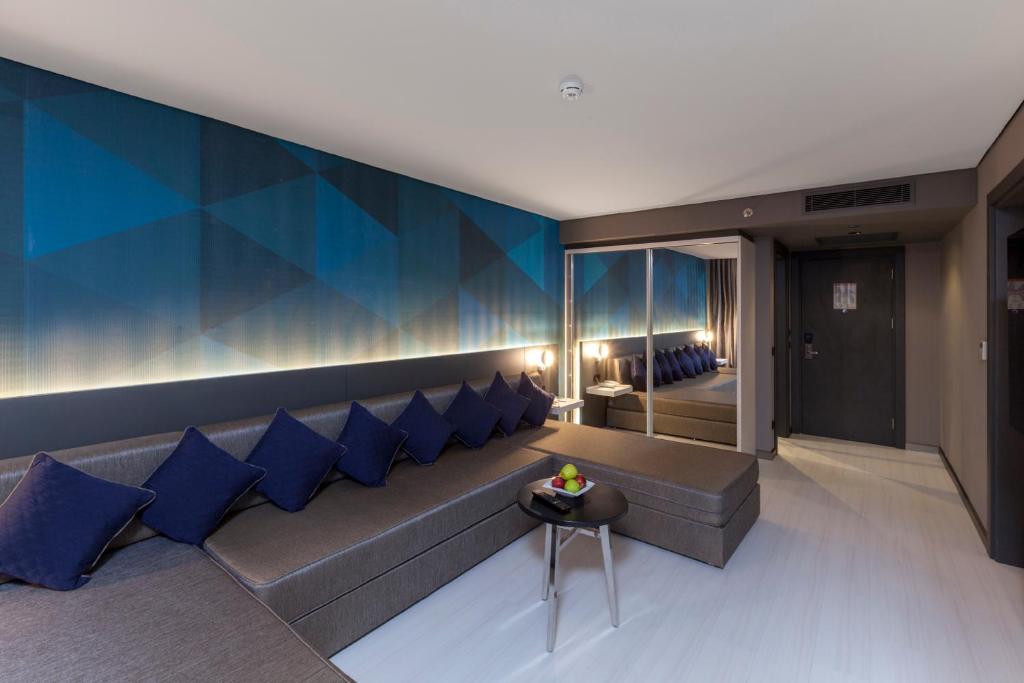 Mūsdienīgs numurs ar zilu sienu apdari un ērtu dīvānu Bosphorus Sorgun Hotel.