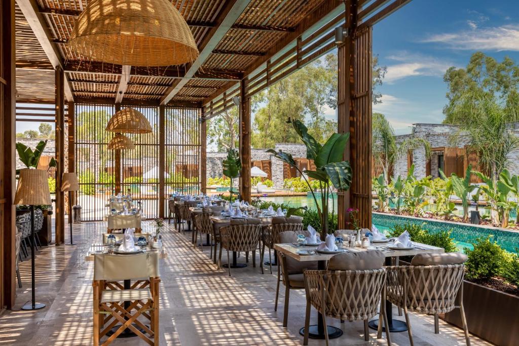 Moderns restorāns pie Kaya Palazzo Golf Resort ar skatu uz baseinu un dārzu.