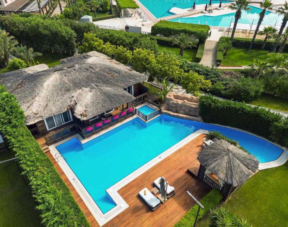 Kaya Palazzo Golf Resort peldbaseins ar tropu stilu māju