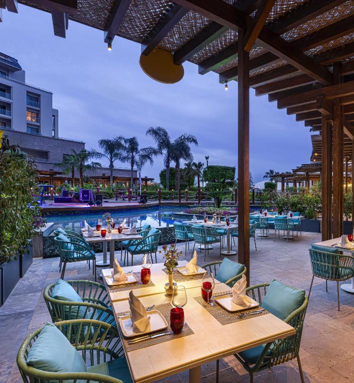 Kaya Palazzo Golf Resort terase pie baseina ar galdiem un ziediem