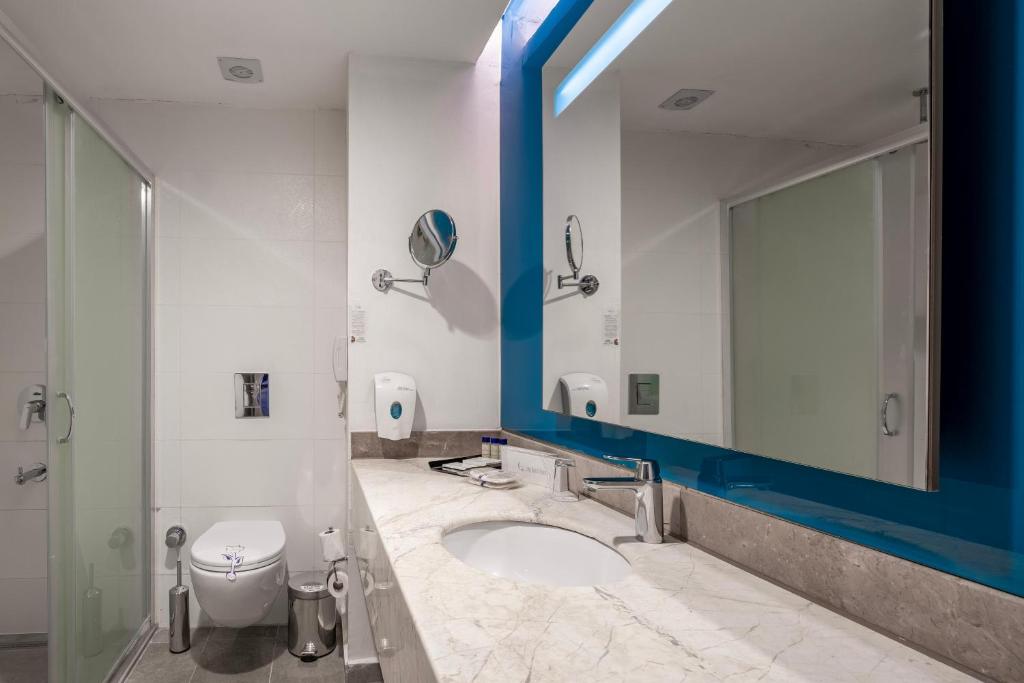 Moderns vannas istaba ar dušu un marmora izlietni Long Beach Resort.